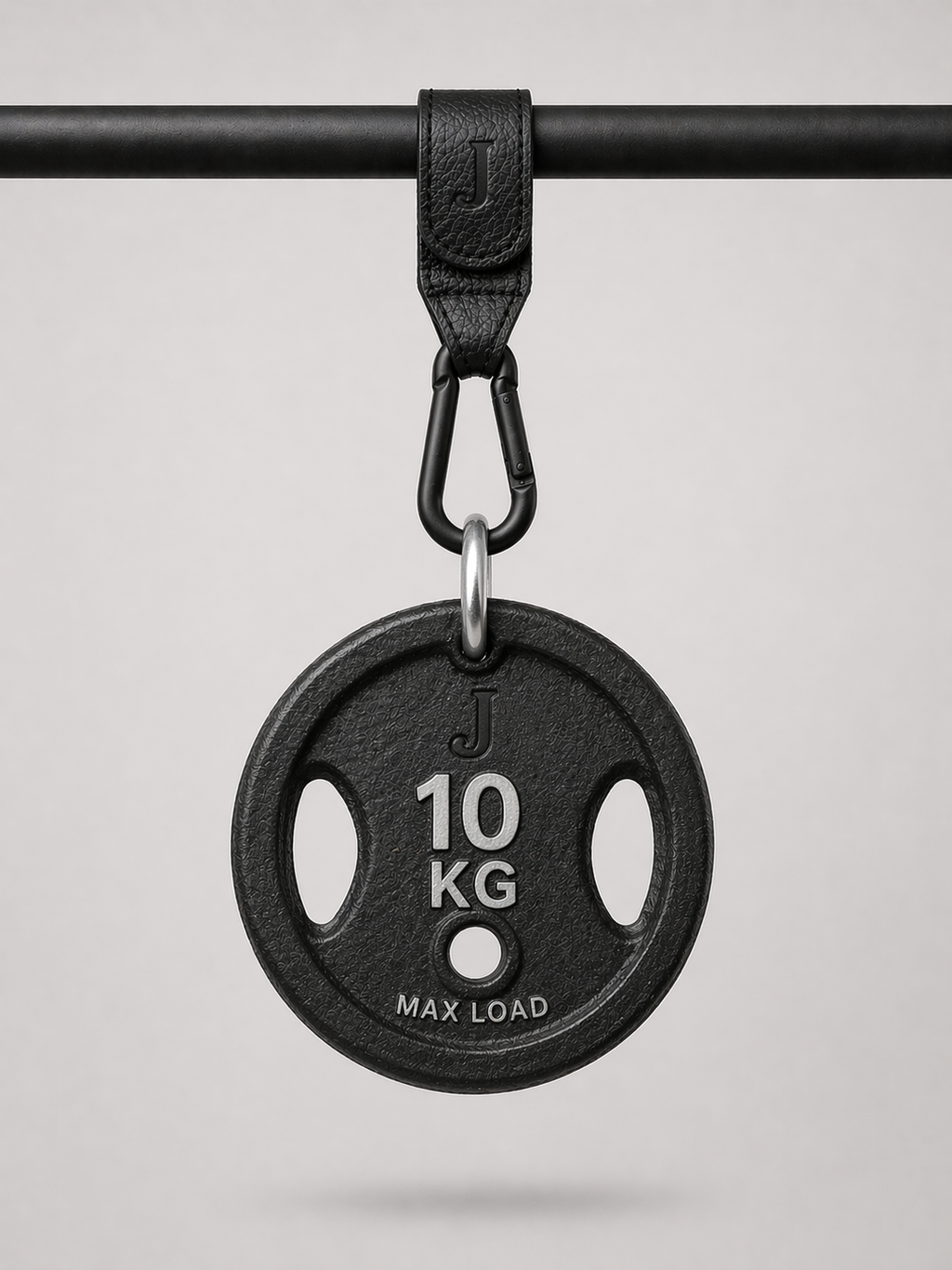 Black weight plate with '10 KG' marking on a gray background being held up by a Josalis The Mira Buggy clip 