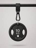 Black weight plate with '10 KG' marking on a gray background being held up by a Josalis The Mira Buggy clip 