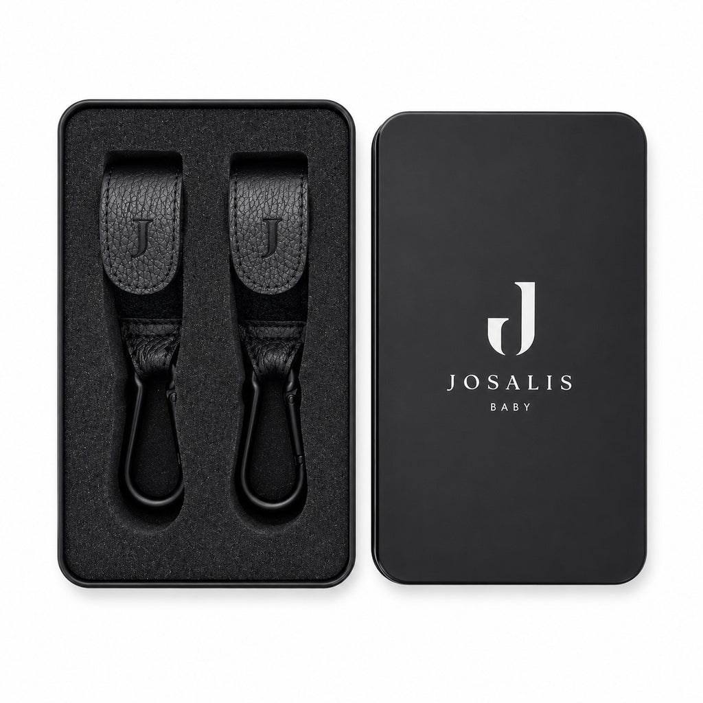 Black leather Buggy clips with metal carabiner hooks, shown in a presentation matte black tin sitting tidily within foam inserts  