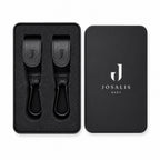 Black leather Buggy clips with metal carabiner hooks, shown in a presentation matte black tin sitting tidily within foam inserts  