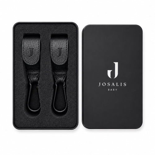 Black leather Buggy clips with metal carabiner hooks, shown in a presentation matte black tin sitting tidily within foam inserts  